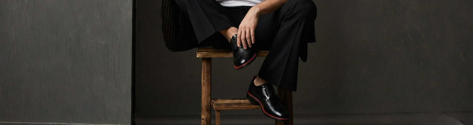 Close-up of Pintta Dublin Black luxury men’s shoes with red welt in a dark editorial setting, highlighting premium leather and quiet luxury design.