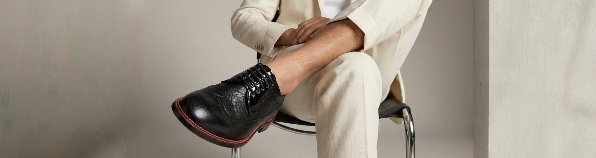 Close-up of Pintta Dublin Black shoes in dark setting, highlighting red welt, premium leather and refined quiet luxury presence.